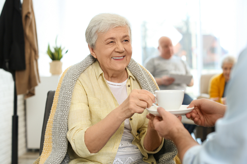 Care worker giving drink to elderly woman in geriatric hospice Care worker giving drink to elderly woman in geriatric hospice