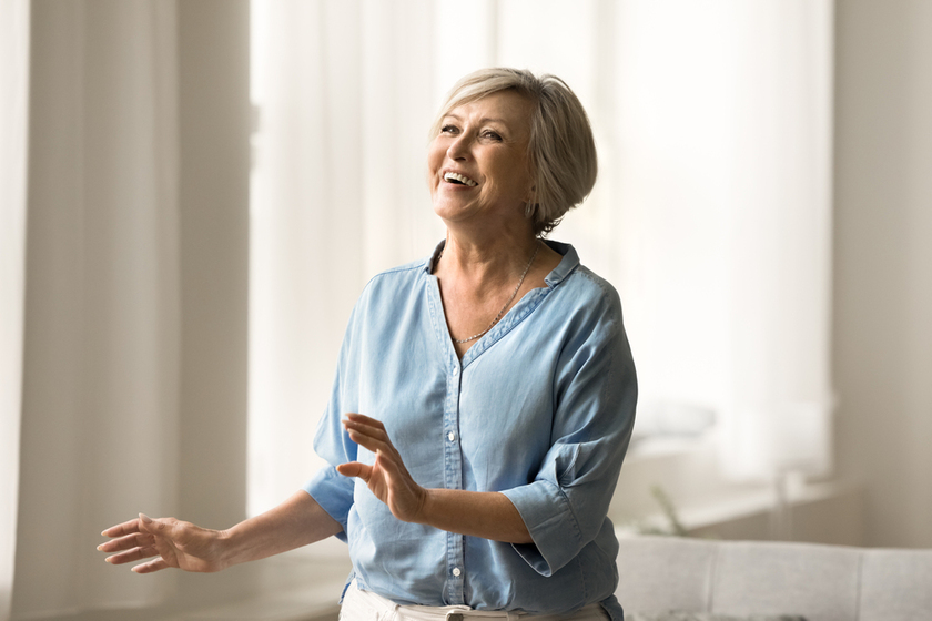 Excited cheerful pretty mature woman having fun at home