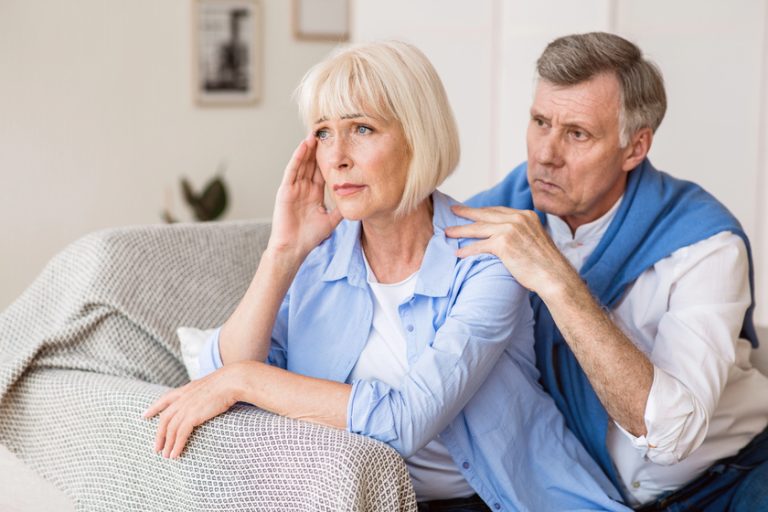 Mature husband and wife arguing, man trying to resolve family conflict at home