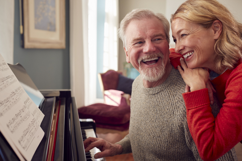 Smiling Senior Couple At Home Enjoying Learning To Play Piano Smiling Senior Couple At Home Enjoying Learning To Play Piano