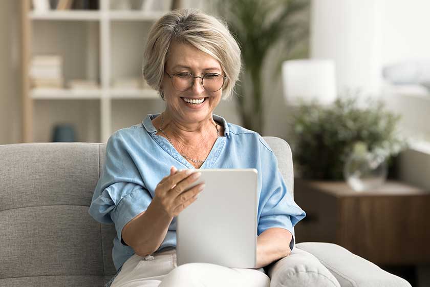 Cheerful-positive-stylish-elderly-lady-talking-video-call-tablet-computer