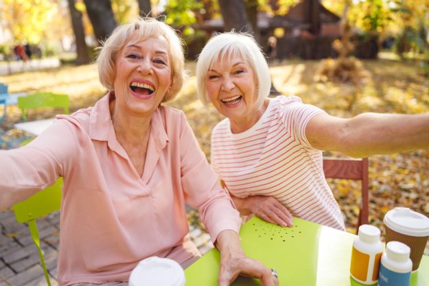 Cheerfully smiling old ladies taking selfie together Cheerfully smiling old ladies taking selfie together