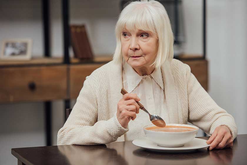Lonely-senior-woman-sitting-table-eating-cream-soup-home Lonely-senior-woman-sitting-table-eating-cream-soup-home