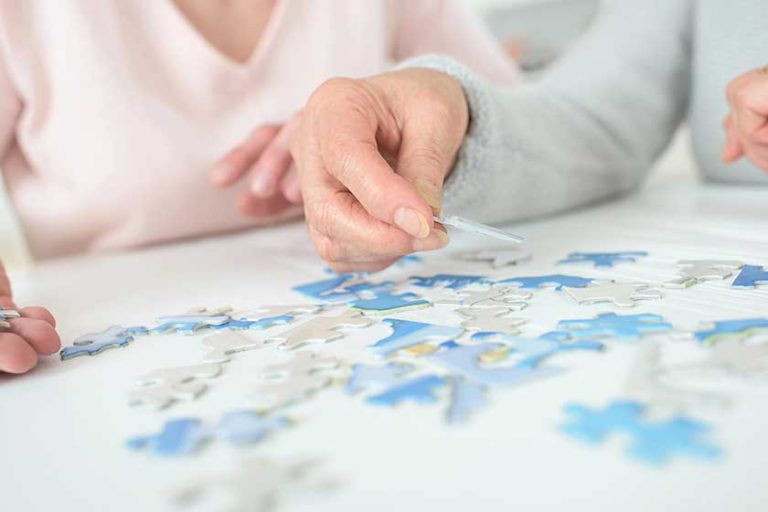 Women-playing-with-jigsaw-puzzle-on-wooden-table Women-playing-with-jigsaw-puzzle-on-wooden-table