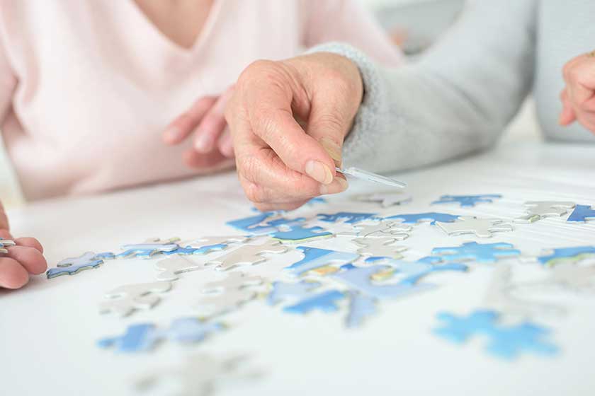 Women-playing-with-jigsaw-puzzle-on-wooden-table Women-playing-with-jigsaw-puzzle-on-wooden-table