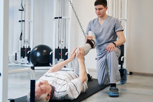 Doctor pulling right leg of pensioner Doctor pulling right leg of pensioner