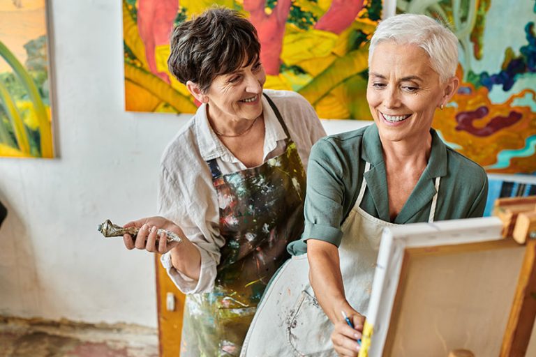Happy middle aged woman painting