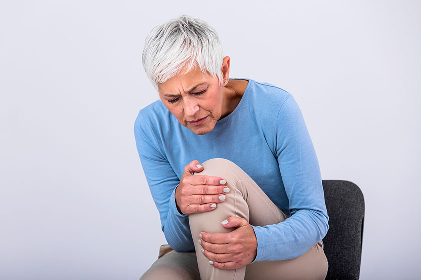 Senior woman holding the knee with pain