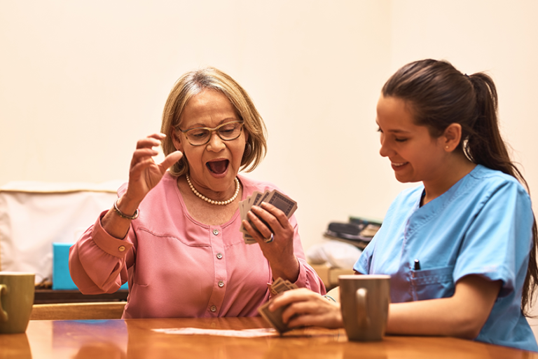 Senior, woman and nurse with playing cards