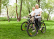 Elderly senior couple rides bicycle in the park
