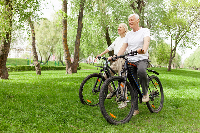 elderly-senior-couple-rides-bicycle Elderly senior couple rides bicycle in the park