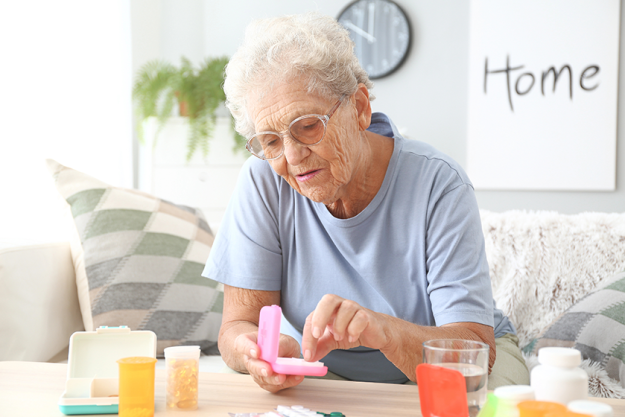 Elderly woman with medicines at home