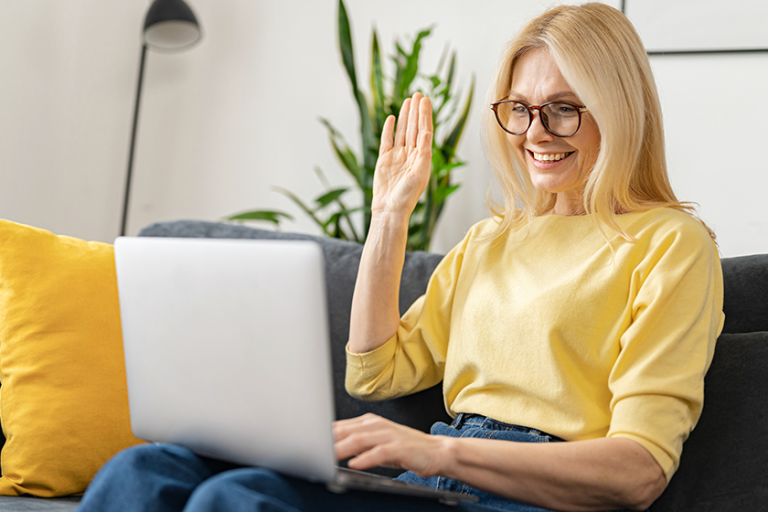 Video call concept. Happy senior woman using laptop