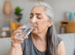 Caucasian elderly gray-haired woman drink water