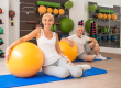Middle-aged couple siting on the mat with fitballs