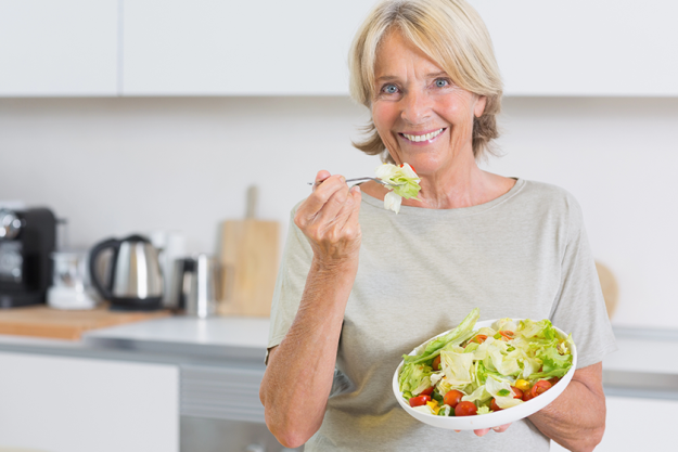 smiling-woman-eating-salad Smiling woman eating salad