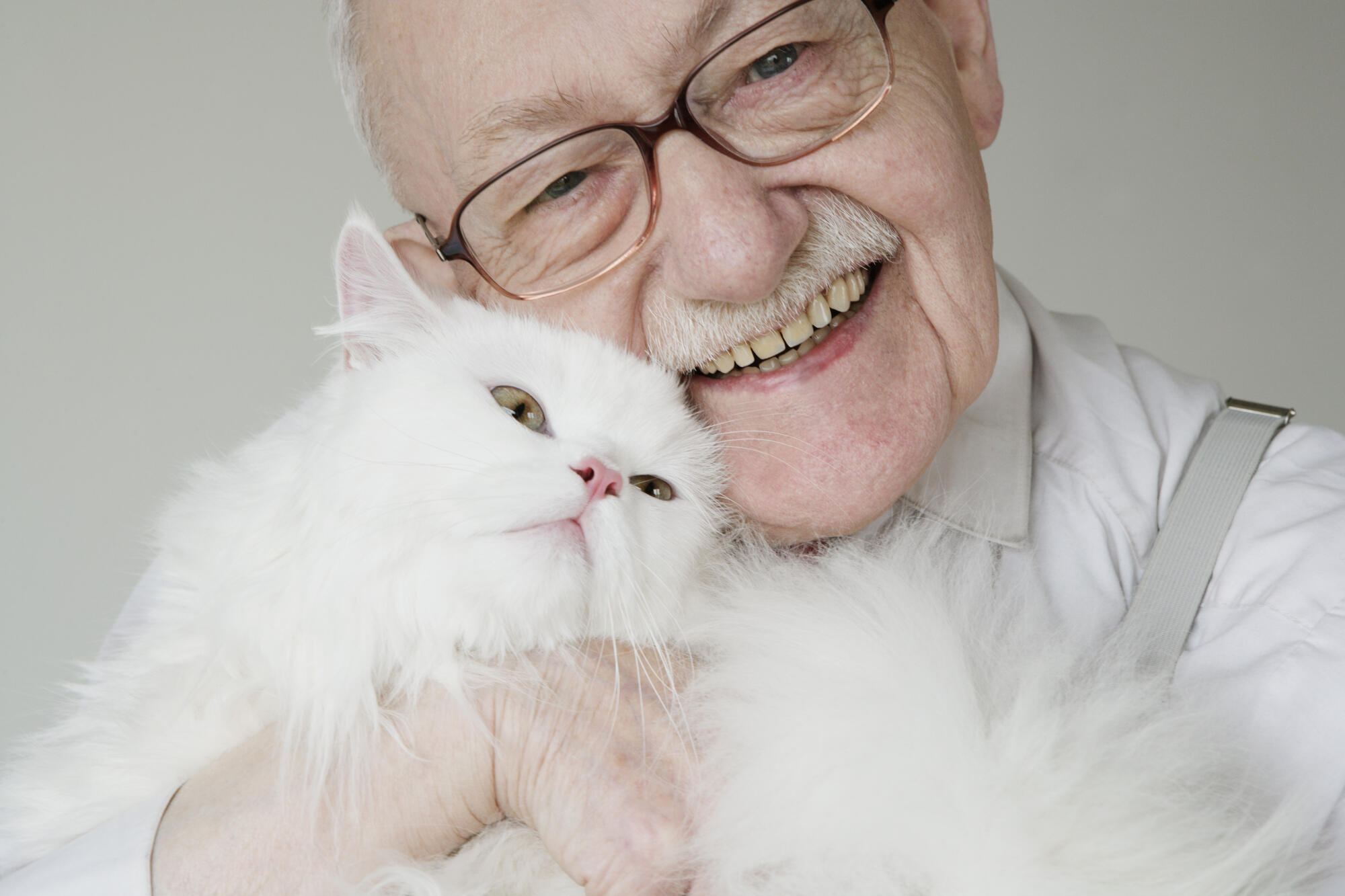 Close,Up,Senior,Man,Hugging,Cat,And,Smiling