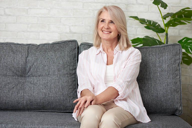 Portrait of beautiful old woman smiling on a sofa