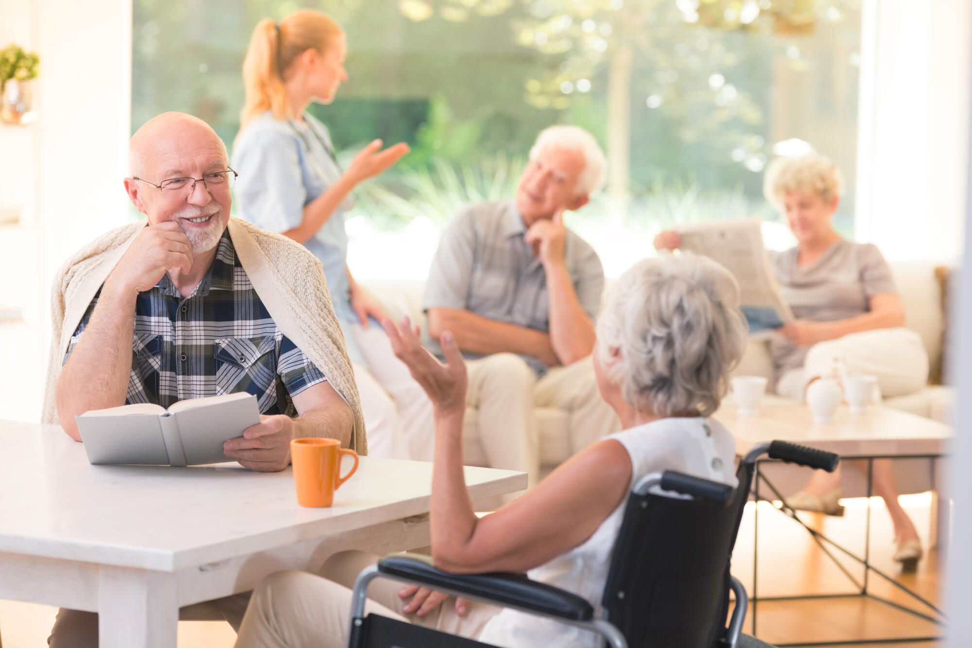 Elderly,Man,Talking,With,Disabled,Woman,While,Sitting,Together,At