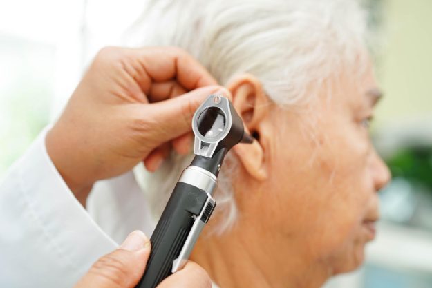 Otolaryngologist or ENT physician doctor examining senior patien