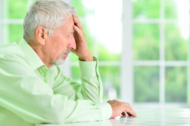 close-up portrait of a senior man thinking about something