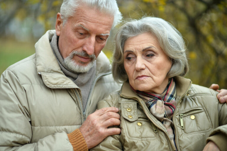 Portrait of sad senior couple in park