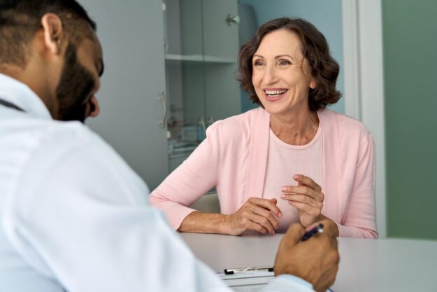 Happy,Older,Mature,Female,Patient,Talking,To,Indian,Male,Doctor