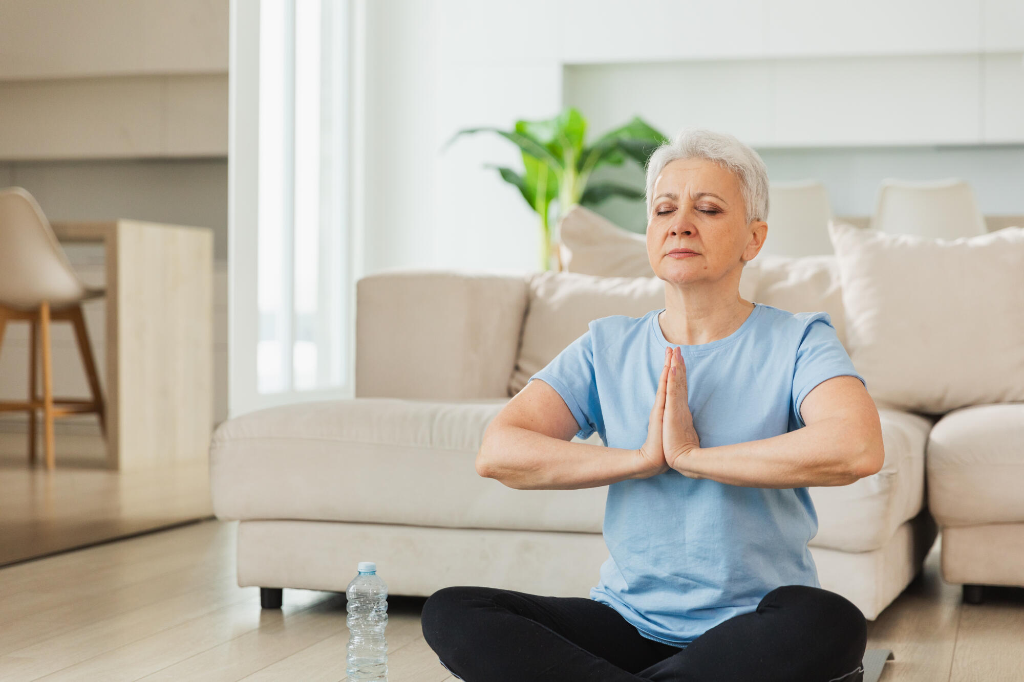 Yoga mindfulness meditation. Senior adult mature woman practicing yoga at home. Mid age old lady sitting in lotus pose on yoga mat meditating relaxing, Older middle aged woman doing breathing practice