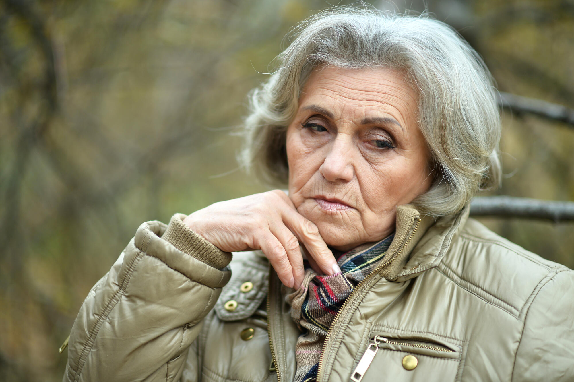 Portrait of senior sad woman in park