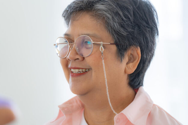 Portrait of elderly smiling Asian woman and people aerobics in n