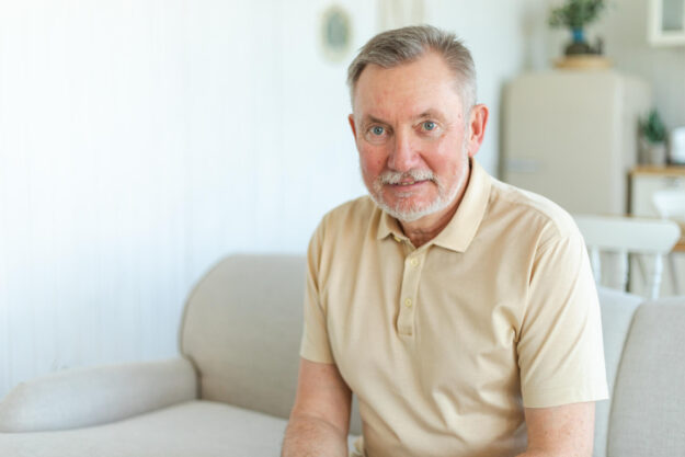 Confident stylish middle aged senior man at home. Older mature 70s man smiling. Happy attractive senior beard grandfather looking camera close up face headshot portrait. Happy people.